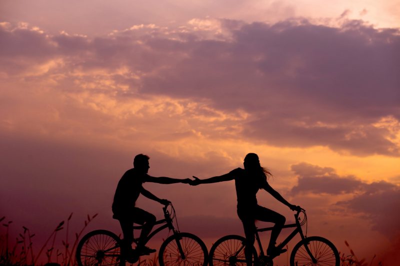 Two people biking at sunset