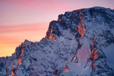 A pink and orange sunset over the Grand Teton Mountain Range in Wyoming.